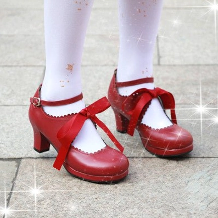 Bright red lolita high heel shoes with patent glossy leather, red satin ribbon bow, ankle strap buckle, scalloped vamp paired with white lolita socks on outdoor tiled flooring