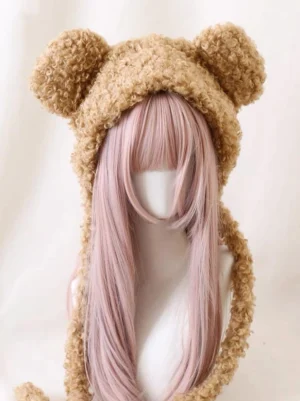 Brown teddy bear ear winter hat upper body frontal view showing fluffy texture and decorative side straps