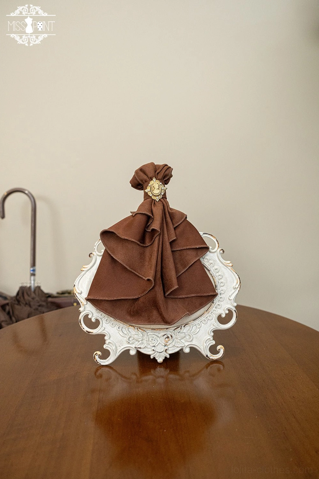 Brown lolita bow tie brooch accessory flat lay chocolate satin ruffled bow gold decorative brooch vintage porcelain tray display