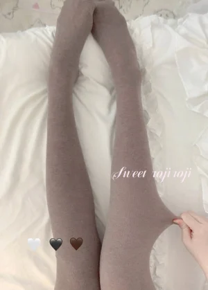 Rich brown thickened fleece lolita pantyhose flat lay with hand showing waist opening detail on white bedding background