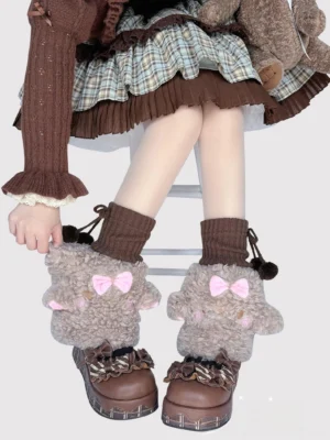 Brown curly plush lamb-style lolita leg warmers with pink bow and pom-pom details on model wearing brown knit top plaid ruffled skirt and brown platform shoes
