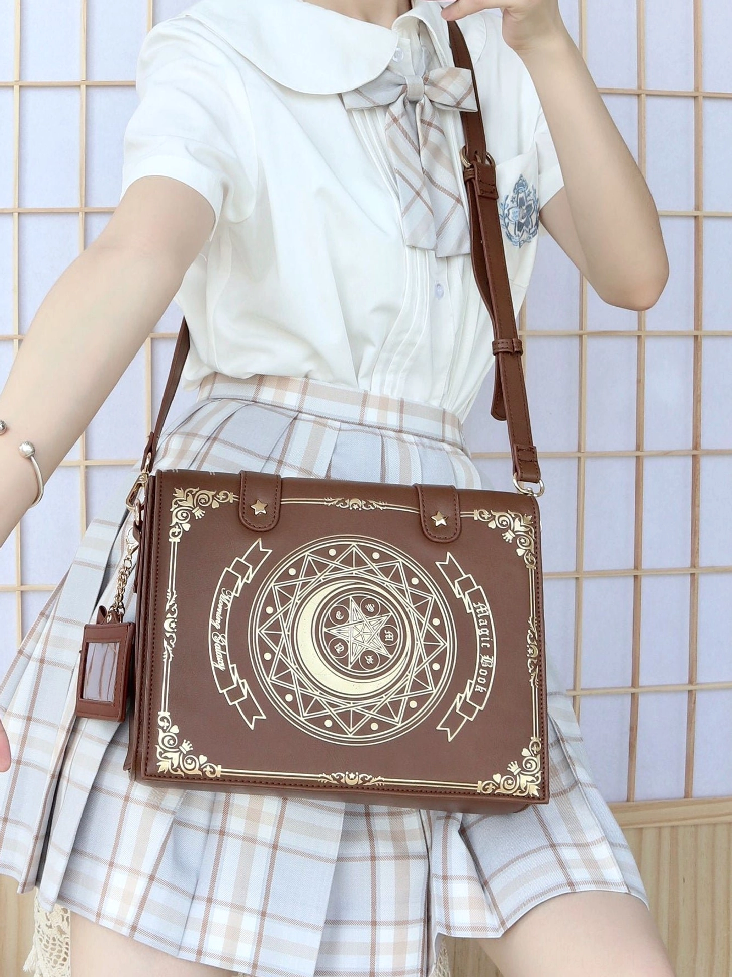Brown leather magic book lolita crossbody bag side view on model wearing sweet sailor collar school-style lolita outfit with adjustable strap
