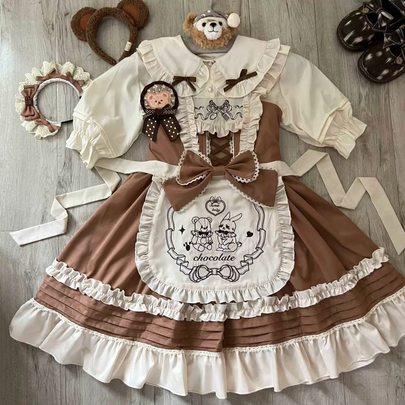 Complete brown maid-style lolita ensemble flat lay, showing JSK dress, bear rabbit embroidered apron, bear ear accessories, matching brown leather shoes