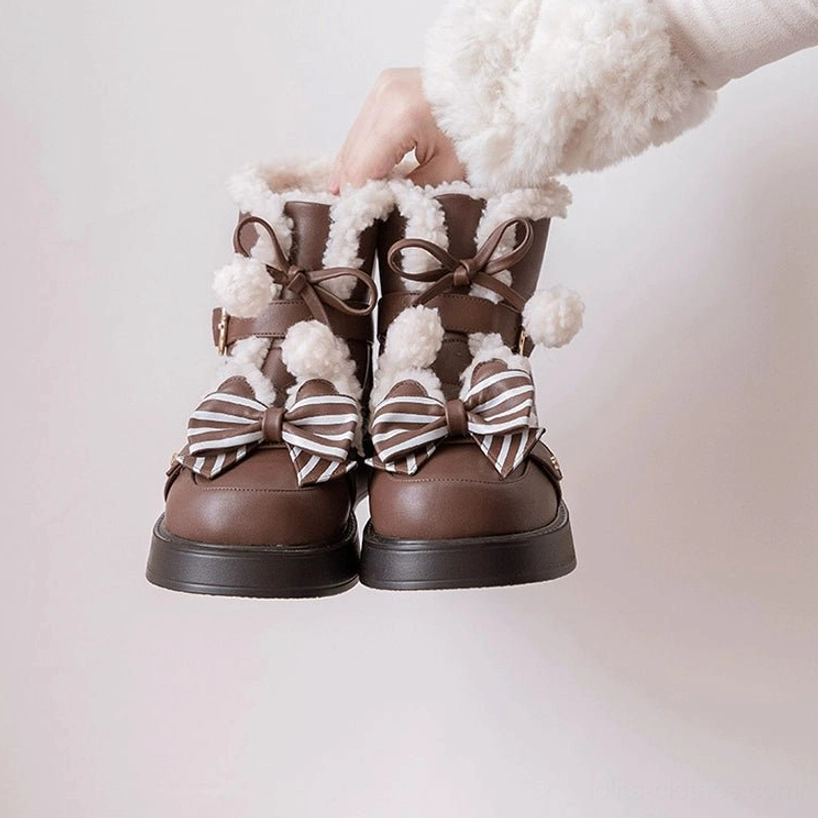 Top-down flat lay display of brown lolita snow boots hand adjusting boot strap fuzzy fur trim striped bow and metal buckle design minimalist white background