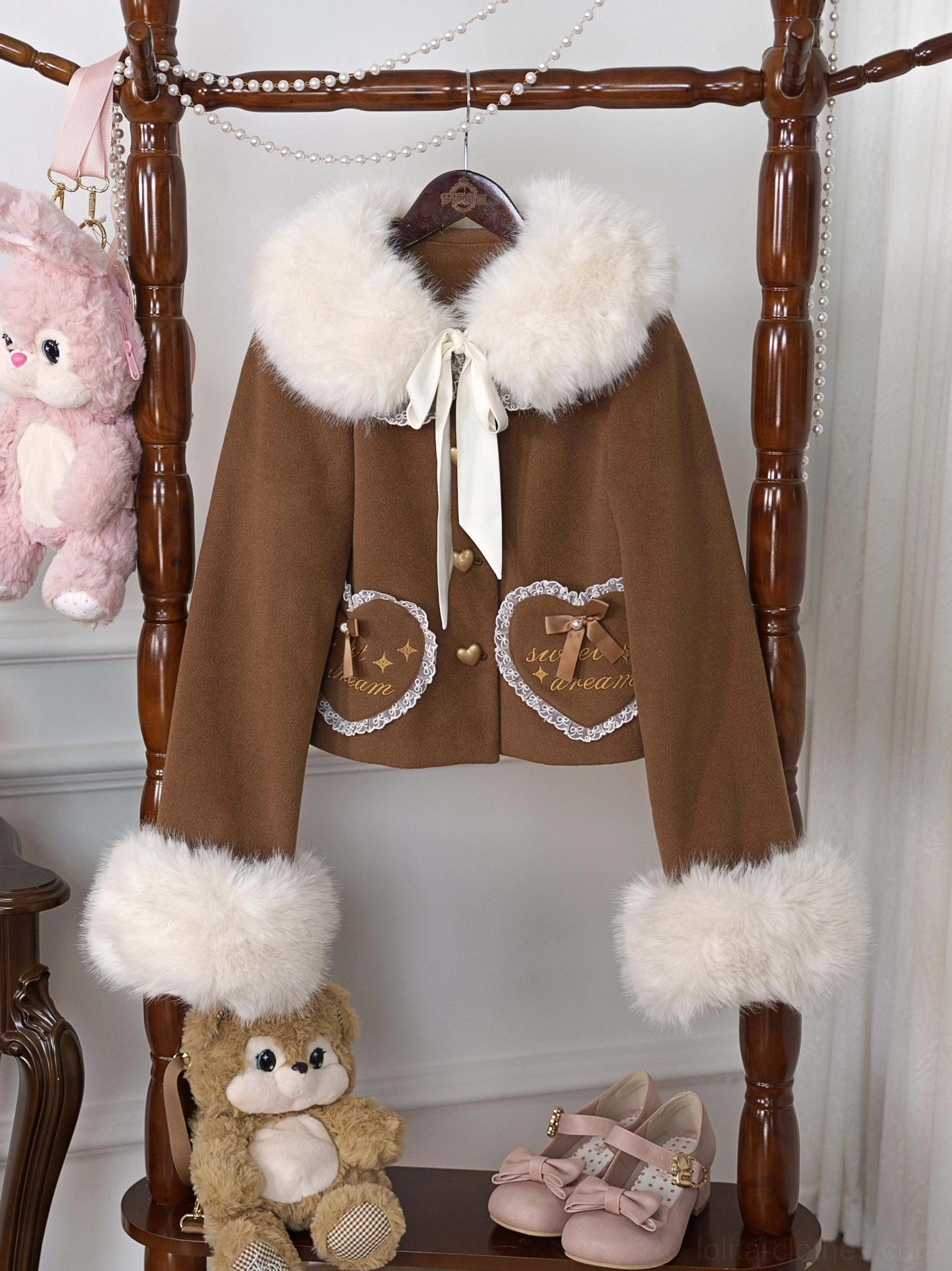 Brown fleece-lined sweet lolita coat with detachable faux fur collar and heart-shaped embroidered pockets, displayed on vintage wooden rack with lace trim and satin bow details