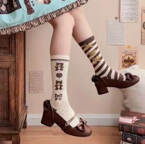 Brown Victorian Mary Jane Lolita high heel shoes worn on-foot with striped Lolita socks and complete Lolita outfit, side angle view showcasing bow detail and block heel