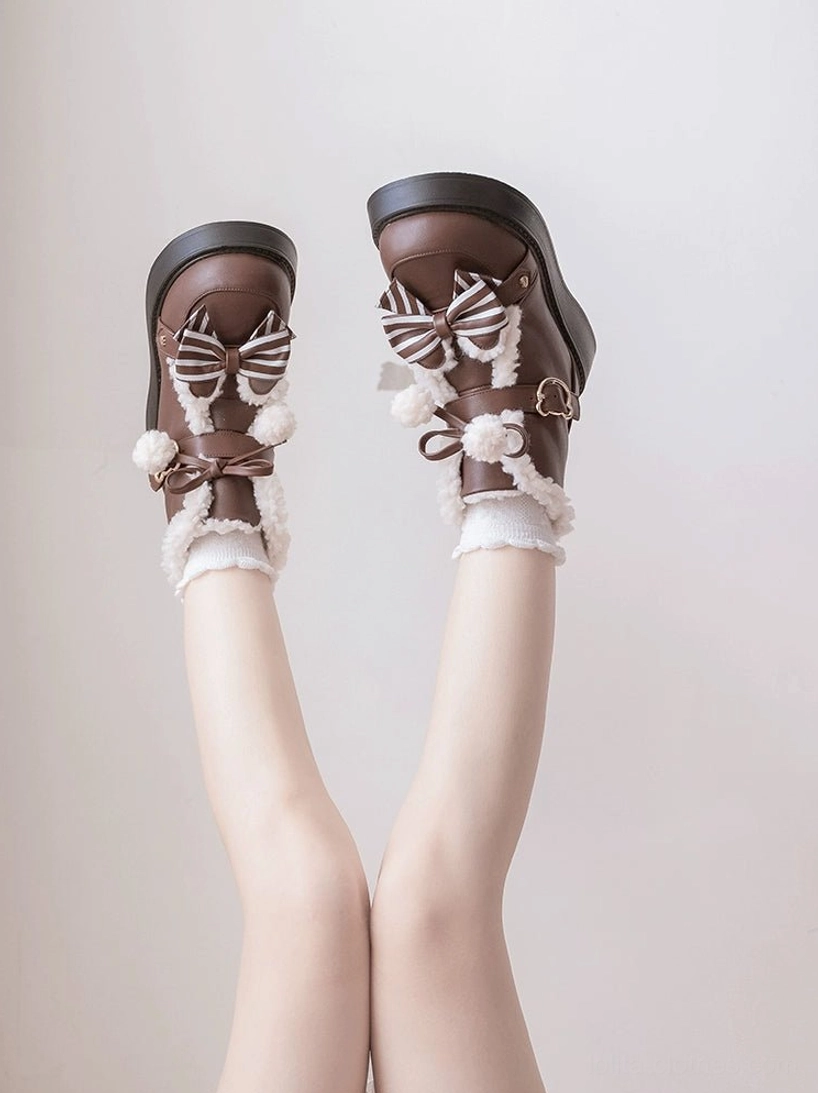 Front view low angle shot of brown fleece-lined lolita winter boots with thick platform sole striped bow metal buckle detail paired with frilly lace socks