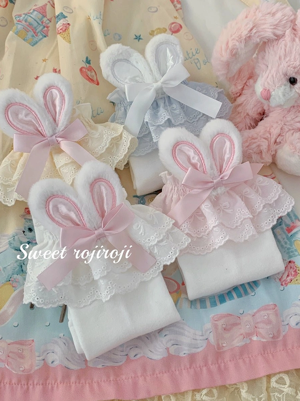 Bunny ear lolita short socks pink and light blue variants flat lay display on carousel print skirt plush toy