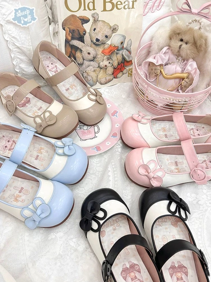 Overhead flat lay display of bunny ear Mary Jane lolita flat shoes in multiple colorways including black khaki pink and sky blue with vintage toy background and decorative props