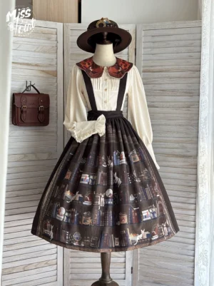 Front view of burgundy classic lolita suspender skirt with library print worn by dress form with fedora hat, showing high waist wine red suspenders and off-white ruffled collar blouse
