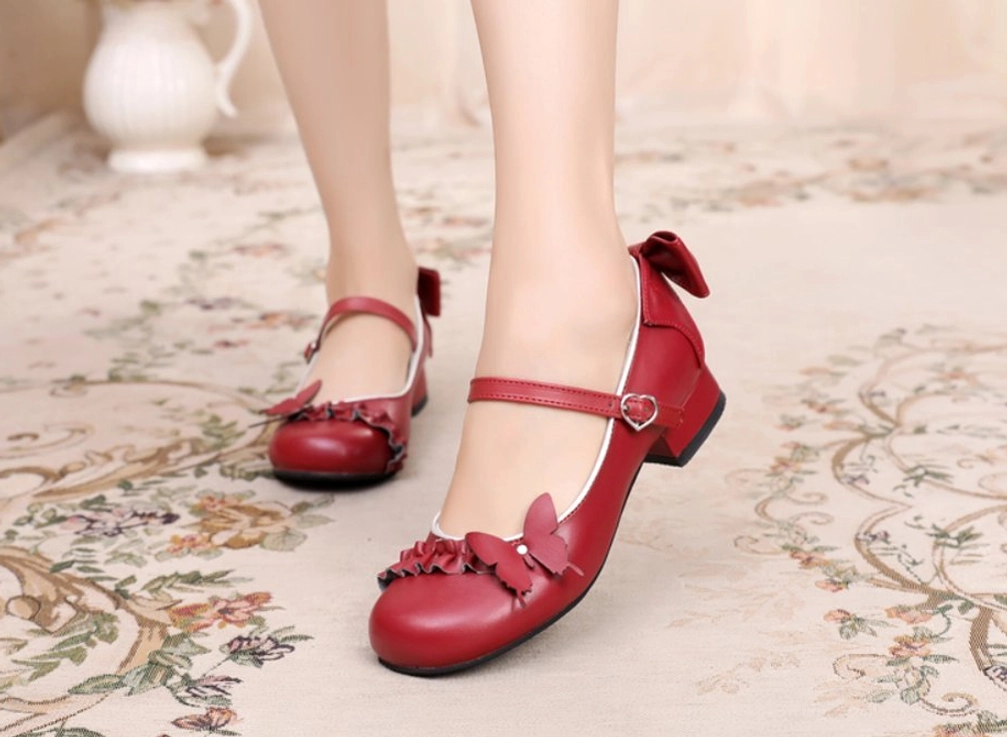 Burgundy sweet Lolita Mary Jane shoes with butterfly toe decoration and heart buckle strap worn overhead side view on model