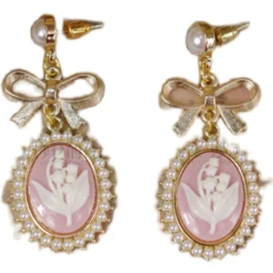 Pair of cameo bow drop earrings close-up front view showing pink oval cameo with embossed lily flower and pearl rim
