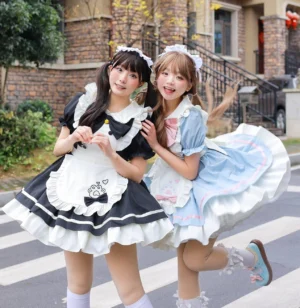 Cat maid lolita dress side dynamic shot showing puffed short sleeves, detachable ruffled apron, front neck bow, flared tiered skirt, outdoor residential area