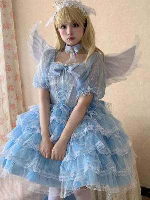 Sky blue celestial wedding lolita OP dress with angel wings, puff short sleeves, layered ruffle tulle skirt, lace trims, and matching choker accessory on blonde model