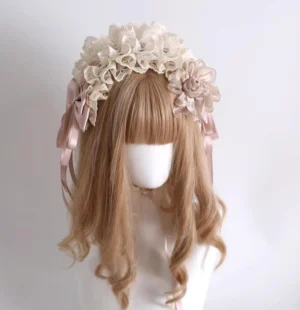 Champagne Lolita floral headband front view on mannequin showing ivory ruffled lace trim, dusty pink satin bows, and fabric flower ornaments