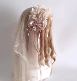 Champagne Lolita headdress with dotted tulle veil and lace trim worn on mannequin back left side view, displaying ivory ruffled lace, dusty pink satin bows, and delicate fabric roses