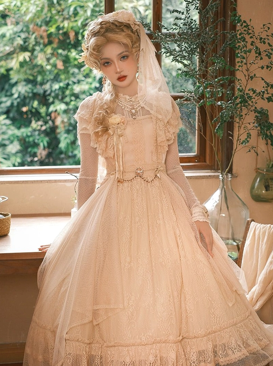 Champagne vintage Lolita OP dress full-length front three-quarter view in sunlit window-side dining area, tulle overlaid full skirt, pearl waist chain, sheer long gloves, veil headwear and chest floral brooch accent