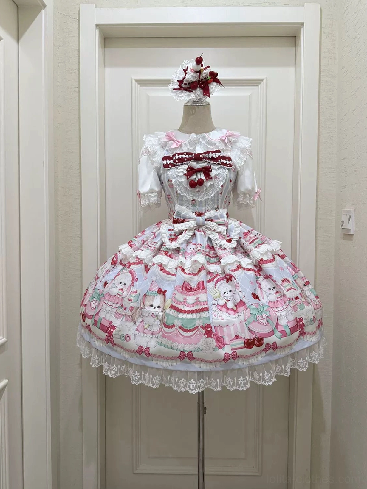 Cherry Bake Song Kawaii Lolita JSK in off-white base on dress form, flat display front view featuring small red bow on white lace collar, cute animal and dessert prints, lace-embellished skirt hem detail