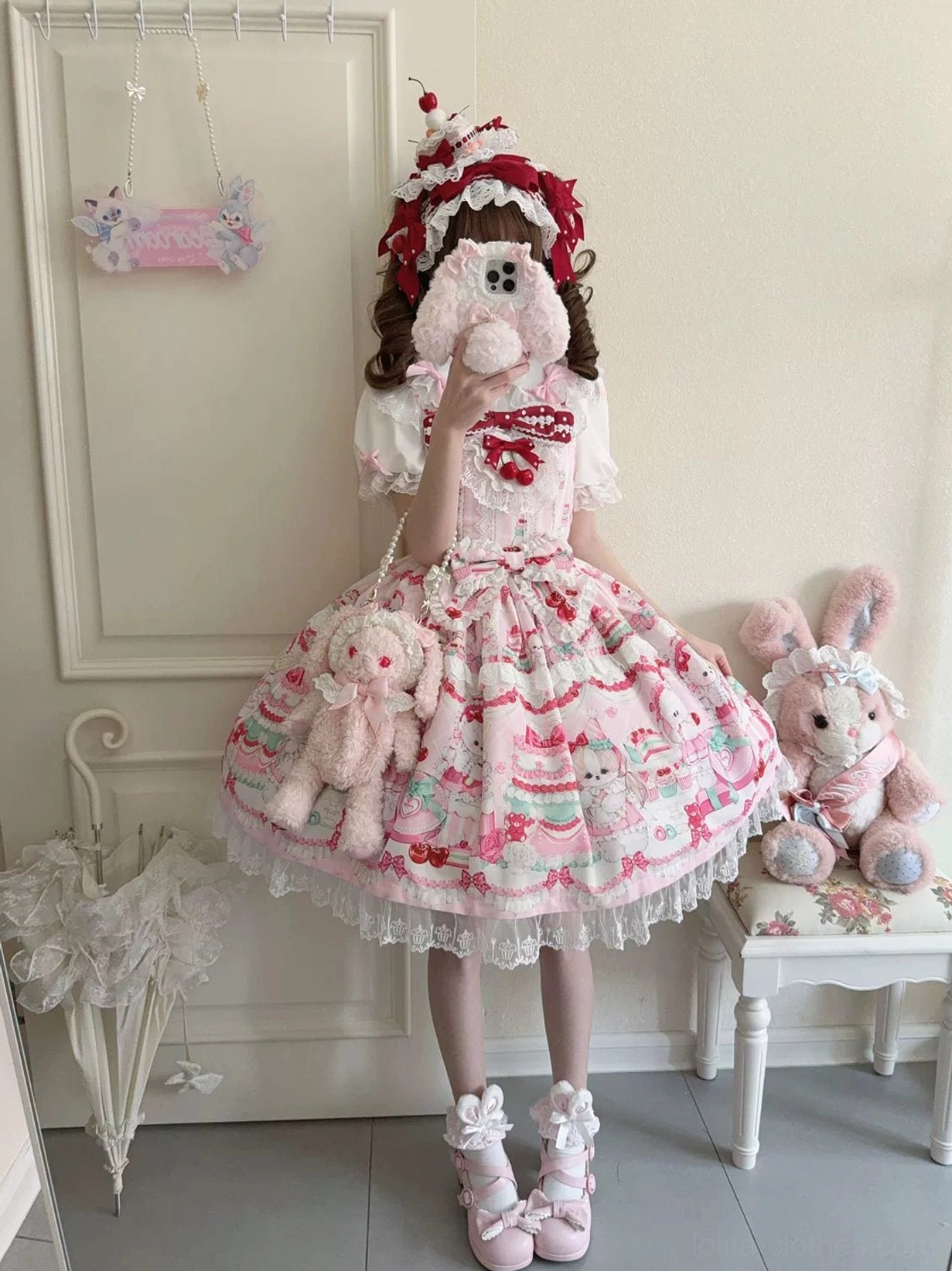 Cherry Bake Song Kawaii Lolita Jumper Skirt in light pink white colorway, full-body front view with model wearing burgundy headbow and fluffy pink shoes, showcasing delicate animal and cake print with lace collar trim
