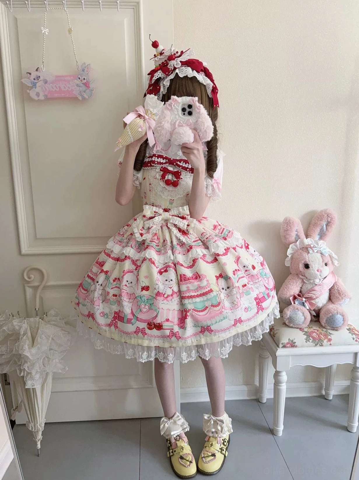 Cherry Bake Song Lolita JSK Dress off-white base with red dessert prints, full-body front view model in burgundy headpiece holding ice cream prop, featuring cute animal companions and embellished lace skirt hem