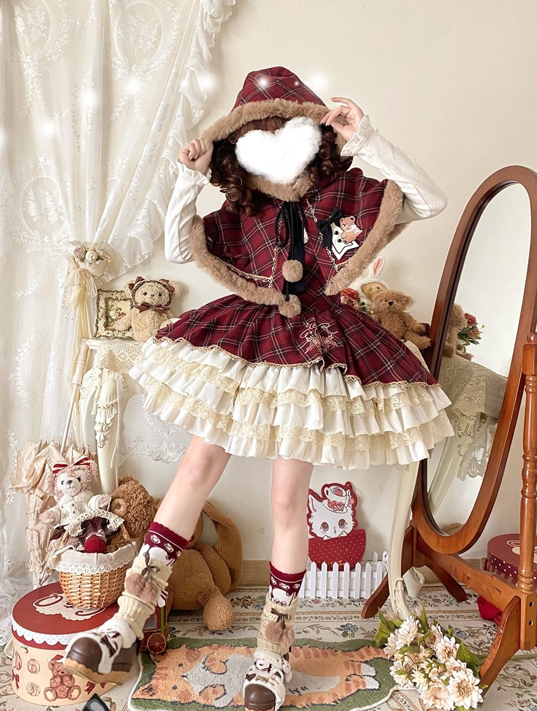 Full front and back view of Christmas plaid lolita JSK with hooded bear cape on mannequin, heart-shaped face cutout, layered ruffled skirt hem, and plush toy display