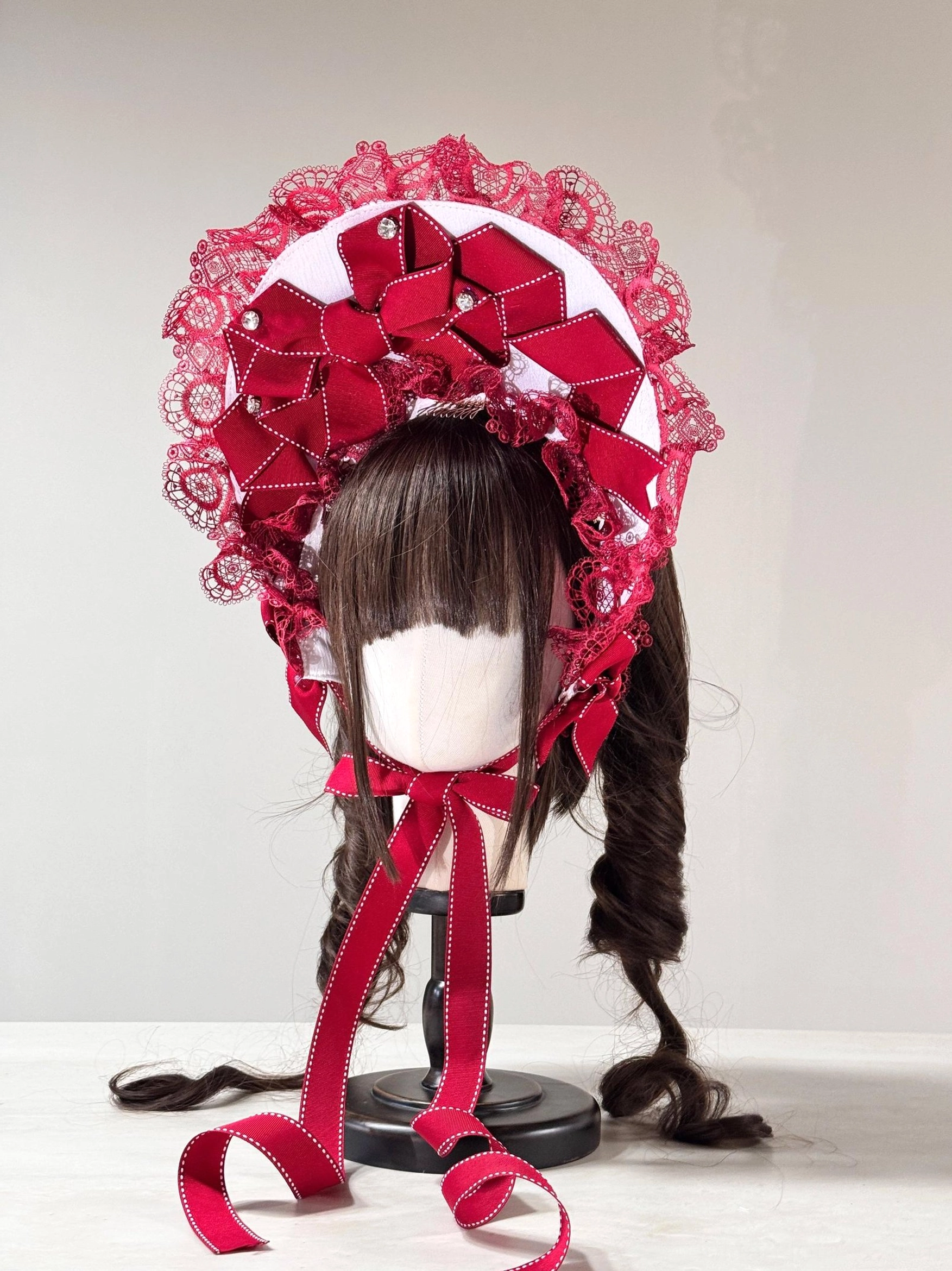 Christmas Sweet Lolita lace head bonnet with white fabric, red satin bows, rhinestone embellishments, ruffled white lace trim, long red neck ties, pearl details, and twin hairstyle styling