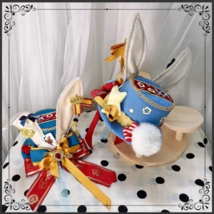 Two sizes of circus-style Lolita bunny ear top hats with blue main color red accents white pompom star ornaments delicate ribbons flat lay polka dot display