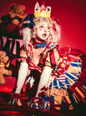 Model wearing circus themed lolita bowknot hand sleeves with clown print dress blue bow tie and white long sleeves studio portrait