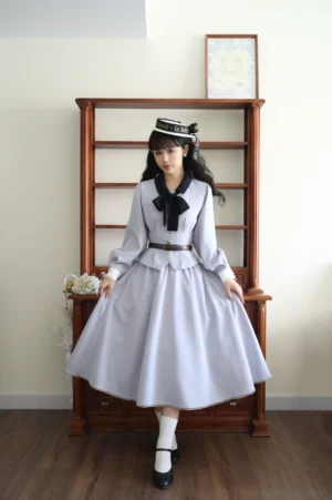 Classic blue daily lolita coordinate set full front view featuring light gray long-sleeve coat with black bow tie, matching pleated A-line skirt with brown leather belt, and coordinating waistcoat on female model wearing sailor hat