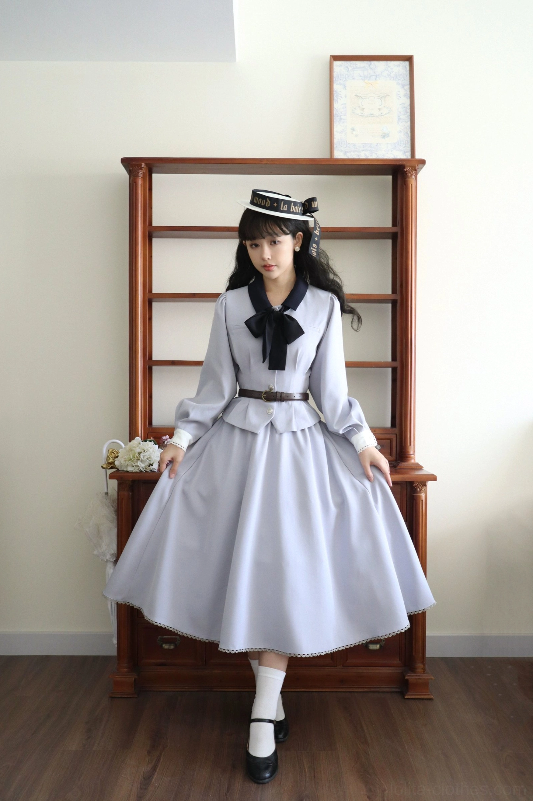 Classic blue daily lolita coordinate set full front view featuring light gray long-sleeve coat with black bow tie, matching pleated A-line skirt with brown leather belt, and coordinating waistcoat on female model wearing sailor hat