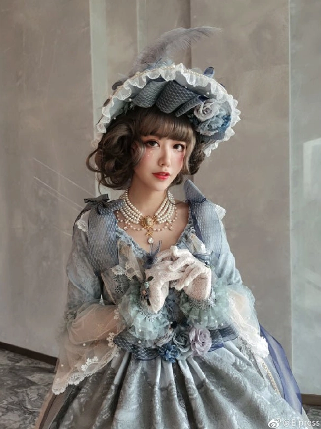 Multi-variant display of classic and gothic Lolita pearl choker necklaces showing white pearl version, black pearl with red stone, and cross pendant variations in styled product photography arrangement