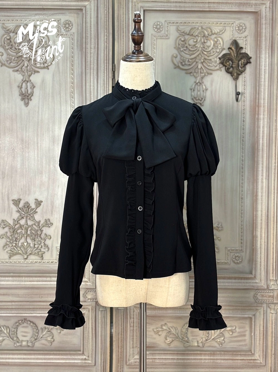 Classic Lolita blouse pure black color front view stand collar with large detachable bow tie puff sleeves ruffled cuffs button placket