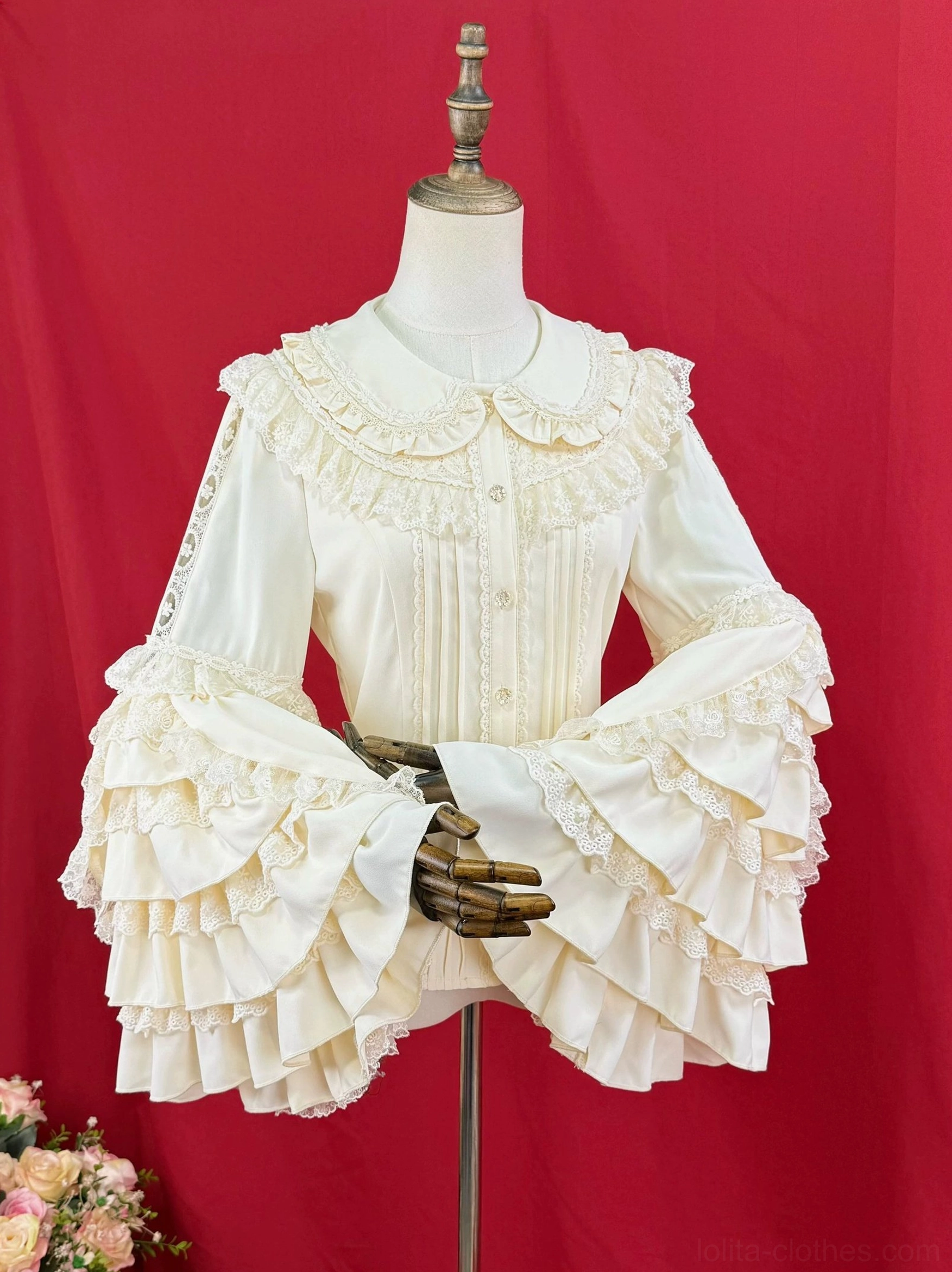 Classic Lolita blouse front placket detail, showing pintucks, button closure, integrated lace trim, and artisanal construction quality on cream white fabric