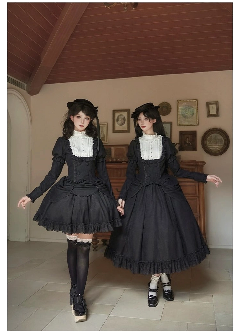 Medium shot of two female models wearing matching lolita blouse and skirt suit with contrast white lace collar, boned corset-style bodice, ruffled hem in studio setting with tiled backdrop, styled with black platform loafers and thigh-high socks