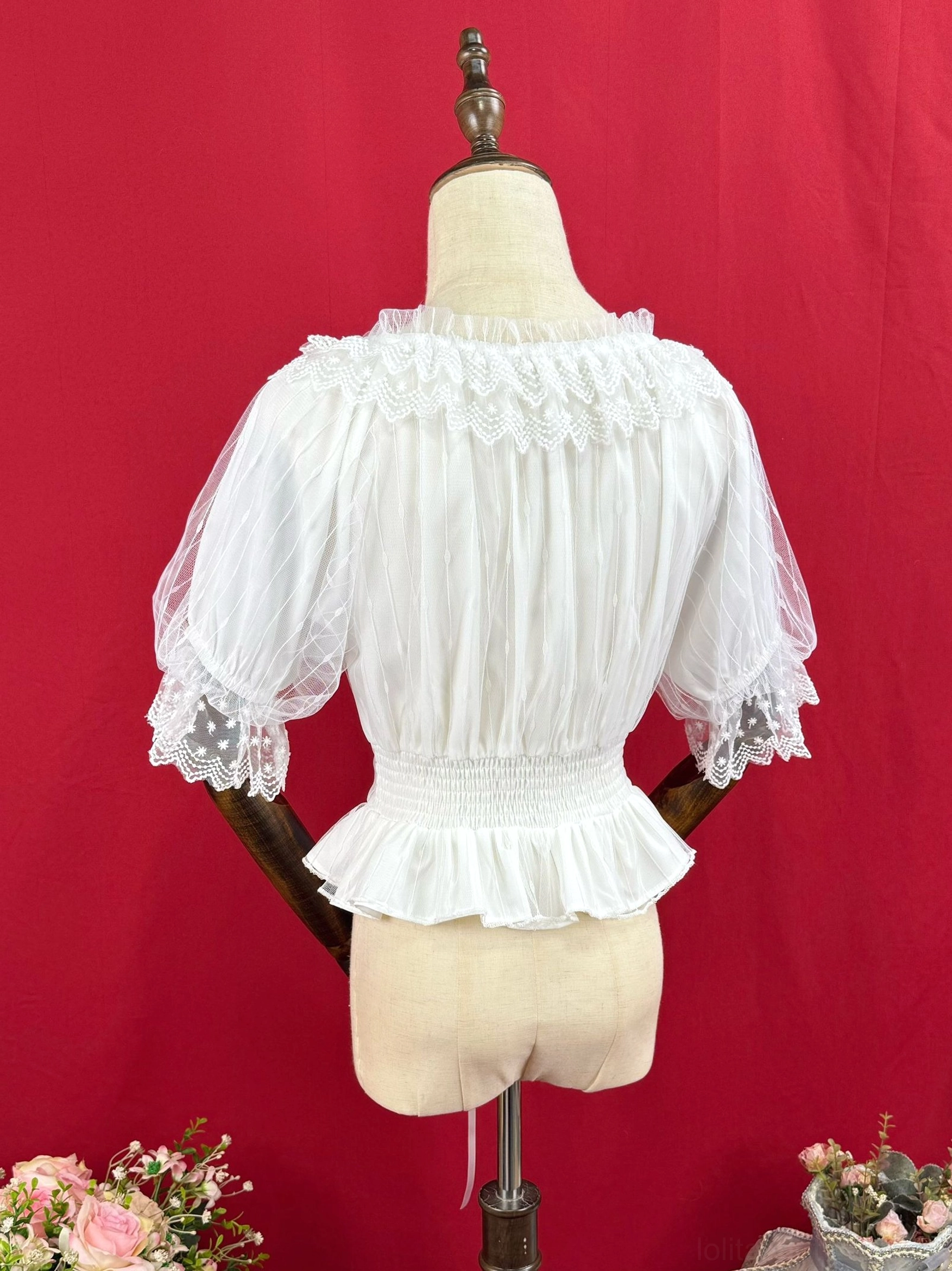 Back view of white classic Lolita blouse showing shirred waist band, ruffled hem, and lace-trimmed mesh puff sleeves on dress form
