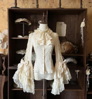 Apricot classic lolita hime sleeve blouse with layered ruffle collar and detachable floral pearl jabot displayed on dress form in vintage wooden cabinet