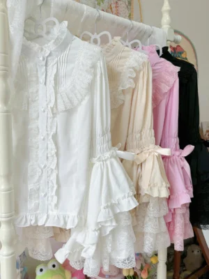 Assorted classic Lolita inner blouses with stand collar, front pin-tuck pleats, and lace-trimmed ruffle cuffs featuring button-down closures on display