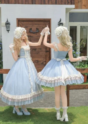 Back view of classic lolita JSK ensemble on twin models showing white satin bow waist tie, exposed square neckline, and layered ruffled skirt hem in garden villa outdoor setting