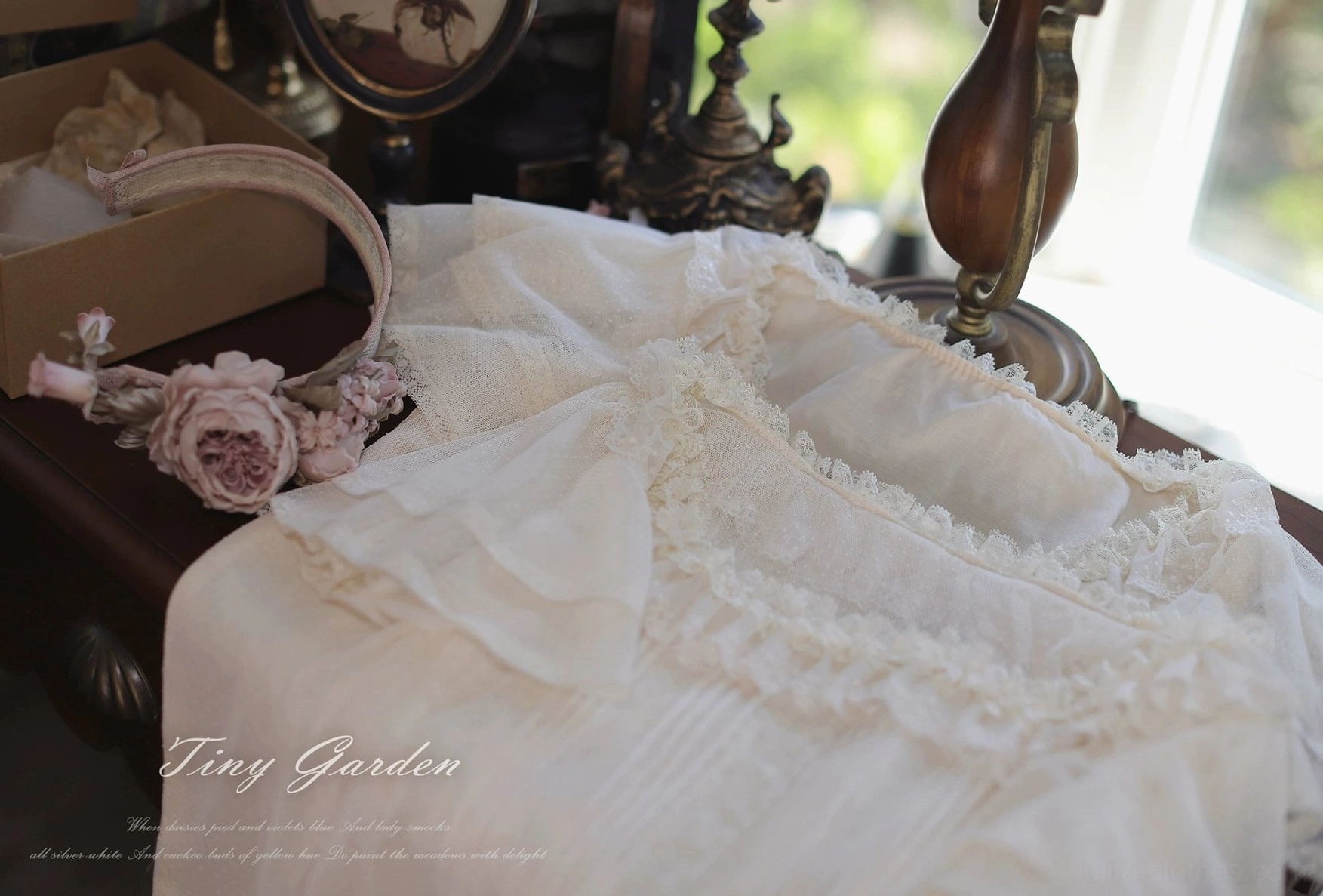 Off-white classic lolita tulle blouse flat lay shot featuring sheer polka-dot tulle, ornate lace ruffled neckline design, vertical pintuck details creating structured bodice and romantic lolita fashion aesthetic