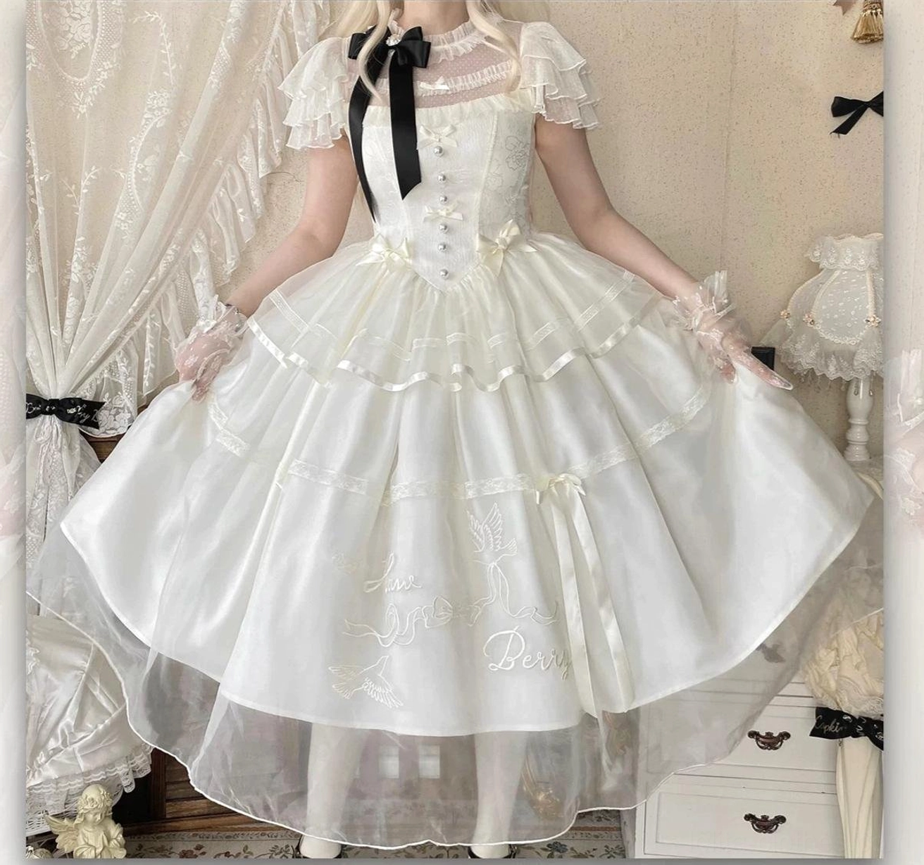 Milky apricot classic lolita OP dress bodice detail featuring black detachable bow collar, three-tier flutter ruffled sleeves, and jacquard weave fabric