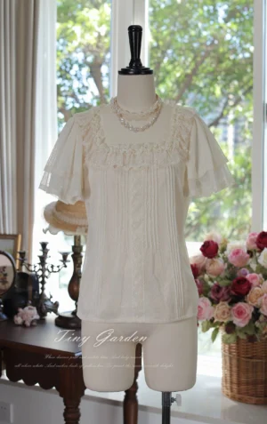 Classic lolita square neck polka-dot tulle blouse front three-quarter angle showcase displaying cream beige color with ruffled flutter short sleeves, delicate lace trim neckline and vertical pintuck pleats in vintage studio setting