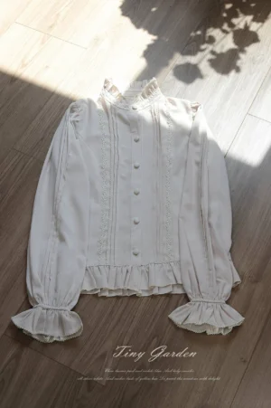 Classic Lolita long sleeve stand collar blouse with pintuck details and ruffled cuffs in apricot chiffon, flat lay top-down view on wooden floor