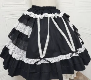 Solid black Classic Lolita tiered skirt with white lace trims and cross ribbon straps front display