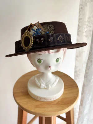 German Bookshelf classic Lolita top hat with vintage brooch and golden gear trim displayed on cat mannequin front close-up view brown wool fabric