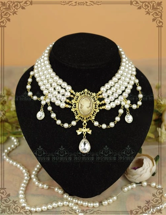Classic white pearl tiered choker necklace with ornate gold cameo center pendant on black velvet jewelry mannequin display, showcasing front view of delicate Lolita jewelry with layered pearl strands and teardrop crystal accents