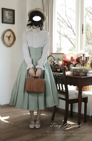 Full body vintage Lolita outfit with white stand collar ruffled blouse paired with sage green high-waisted midi skirt and leather loafers, model wearing straw hat in retro dining room