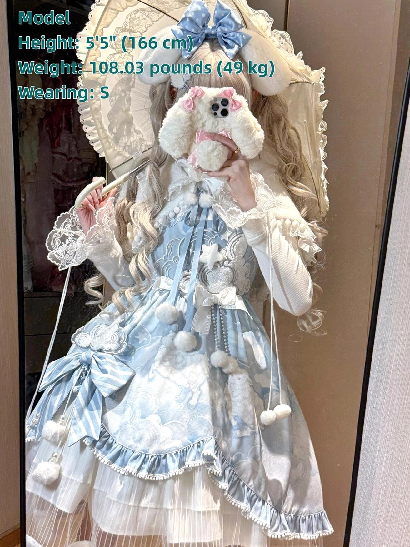 Full Cloudscape Dream lolita ensemble with matching white lace parasol, blonde model with blue bunny ear hairbow, multiple pom-pom decorations on dress body, high neck inner shirt ruffles, front mirror view
