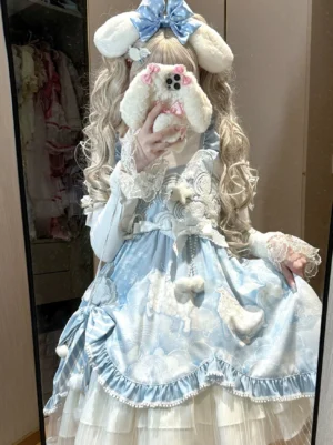 Sweet lolita JSK jumper skirt with cloud print in baby blue and off-white, worn by model with blonde twin tails and blue bunny hairbow, featuring fluffy pom-pom decorations and ruffled trims, front mirror selfie view