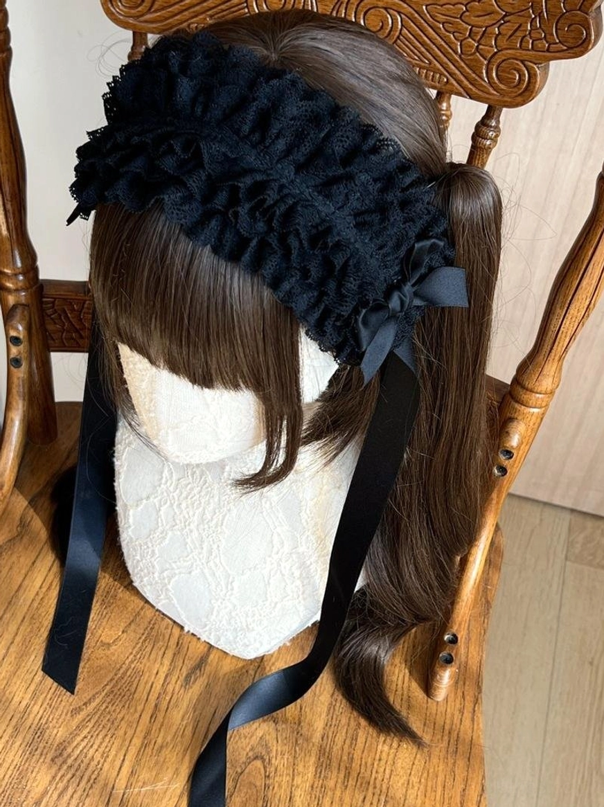 Coffee brown lace KC headdress flat lay product shot on wooden surface, displaying warm brown tone ruffled lace with satin bow details