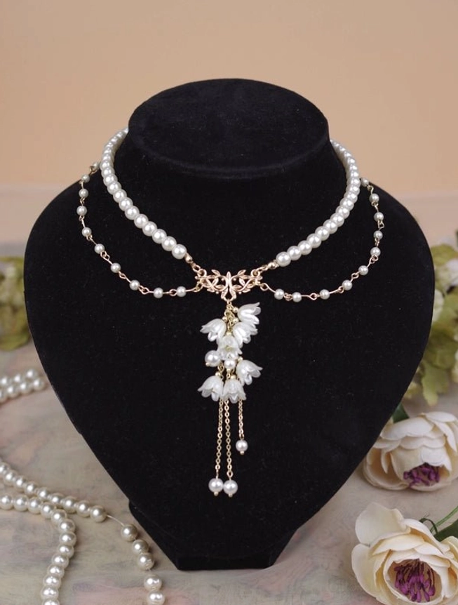Complete layered pearl necklace with lily charms direct front close-up view on jewelry mannequin showing dual-layered chain design central lily tassel pendant with multiple hanging pearls